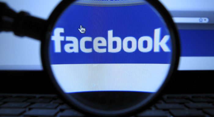 FILE - In this Oct. 10, 2011 file photo, a magnifying glass is posed over a monitor displaying a Facebook page in Munich. Facebook is letting its nearly 1 billion users vote on changes to its privacy policy beginning on Friday, June 1, 2012. This is the second time Facebook let users vote on policy changes. The first time was in 2009 when Facebook was a much smaller, privately held company with about 200 million users (AP Photo/dapd, Joerg Koch)
