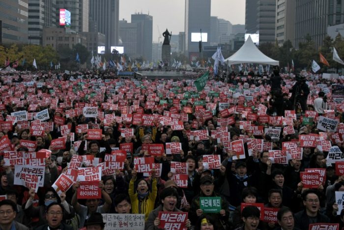 Demonstrators hold placards calling for the resignation of South Korean President Park Geun-Hye in Gwanghwamun square in central Seoul on November 5, 2016. Thousands of South Koreans took to the streets November 5 to demand embattled President Park Geun-Hye resign over a crippling corruption scandal.  / AFP PHOTO / Ed JONES / The erroneous mention[s] appearing in the metadata of this photo by Ed JONES has been modified in AFP systems in the following manner: [Park Geun-Hye] instead of [Park Guen-Hye]. Please immediately remove the erroneous mention[s] from all your online services and delete it (them) from your servers. If you have been authorized by AFP to distribute it (them) to third parties, please ensure that the same actions are carried out by them. Failure to promptly comply with these instructions will entail liability on your part for any continued or post notification usage. Therefore we thank you very much for all your attention and prompt action. We are sorry for the inconvenience this notification may cause and remain at your disposal for any further information you may require.